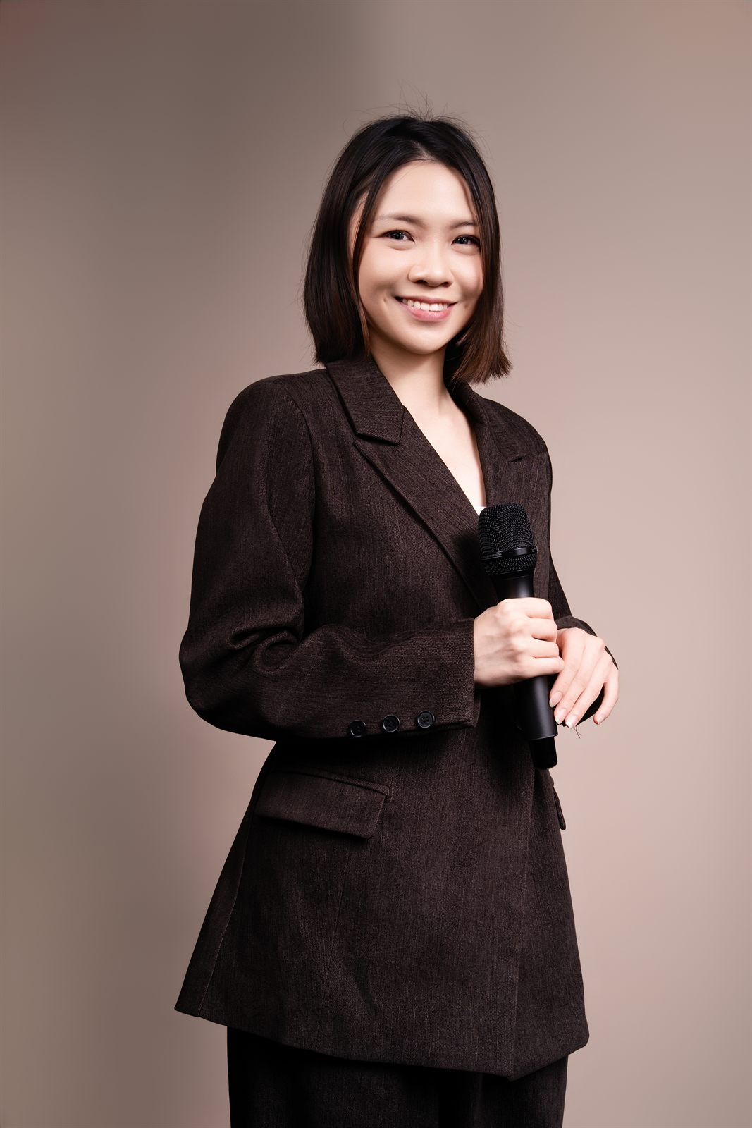 Emcee Yen Lee holding a microphone